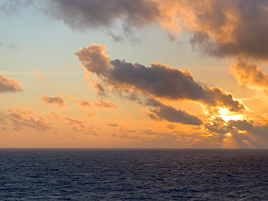 Sun setting behind clouds - December 6, 2023