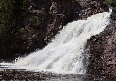 Waterfall beyond white foam