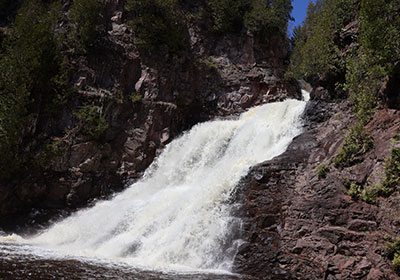 Waterfall crashes into water