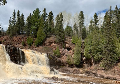 waterfall with trees and rocks in foreground