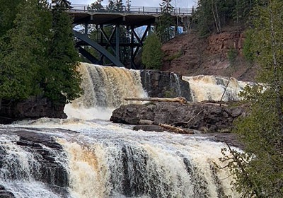Cars drive on bridge over waterfall