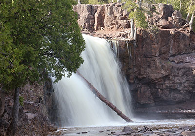 Log in front of waterfall