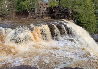 Brownish water falls over waterfall