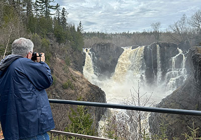 Pat takes picture in front of waterfall