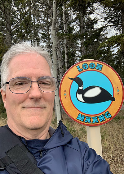 Pat in front of sign of a loon