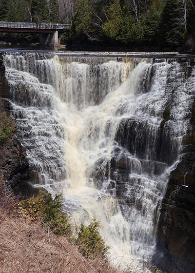 Waterfall with bridge in distance