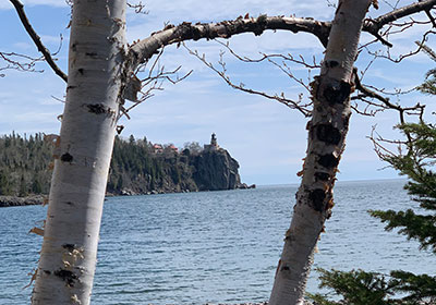 Split Rock State Park lighthoouse in distance beyond two trees