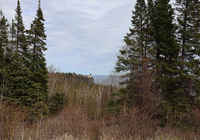 Lighthouse in distance between trees