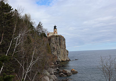 Lighthouse with white clouds in background