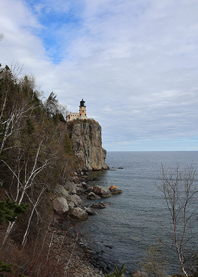 Lighthouse looks over rocks and lake