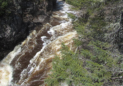 Temperance River flows under cliff