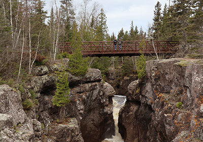 People stand on bridge over river