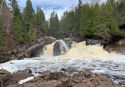 Baptism River flows behind rocks
