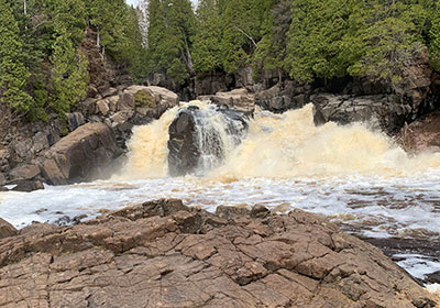 Big rock with waterfall behind it