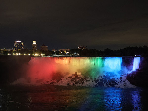 rainbow of light shines on Niagara Falls as viewed from Canadian side