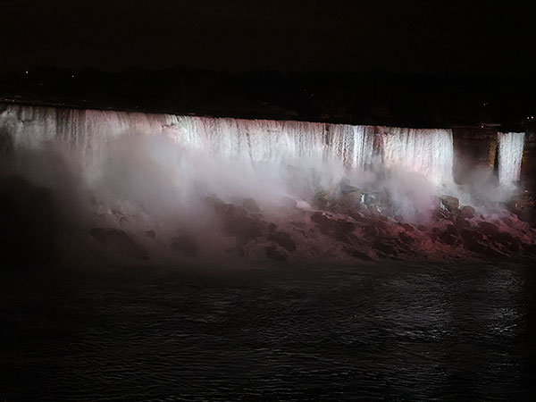 Closeup of white light shines on Niagara Falls as viewed from Canadian side