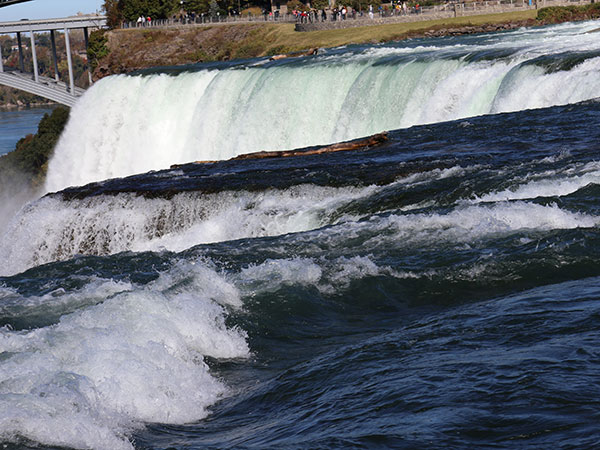 Close up of water flowing over Niagara Falls on American side with white water showing