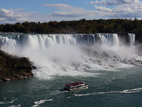 Toourist boat passes in front of Niagara Falls as viewed from Canadian side