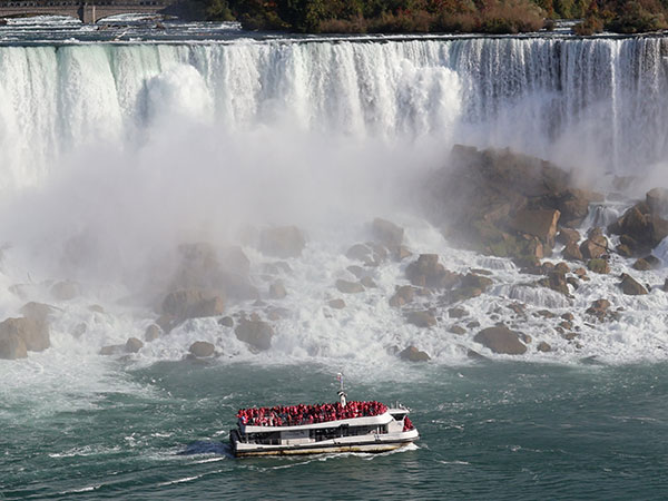 Closeup of boat passing in front of Niagara Falls as viewed from Canadian side