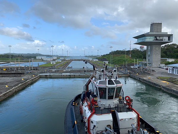 Tugboat behind ship in Panama Canal