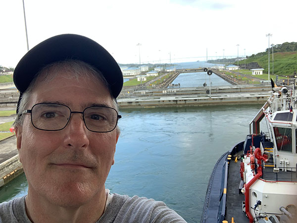 Pat on back of ship with Panama Canal behind