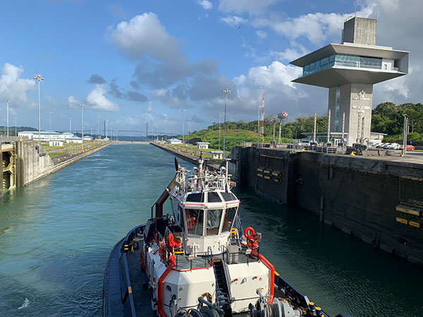 Tugboat pushes ship in Panama Canal withlock closed